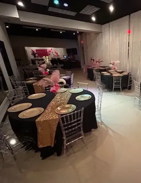 A large room with tables and chairs set up for a party.
