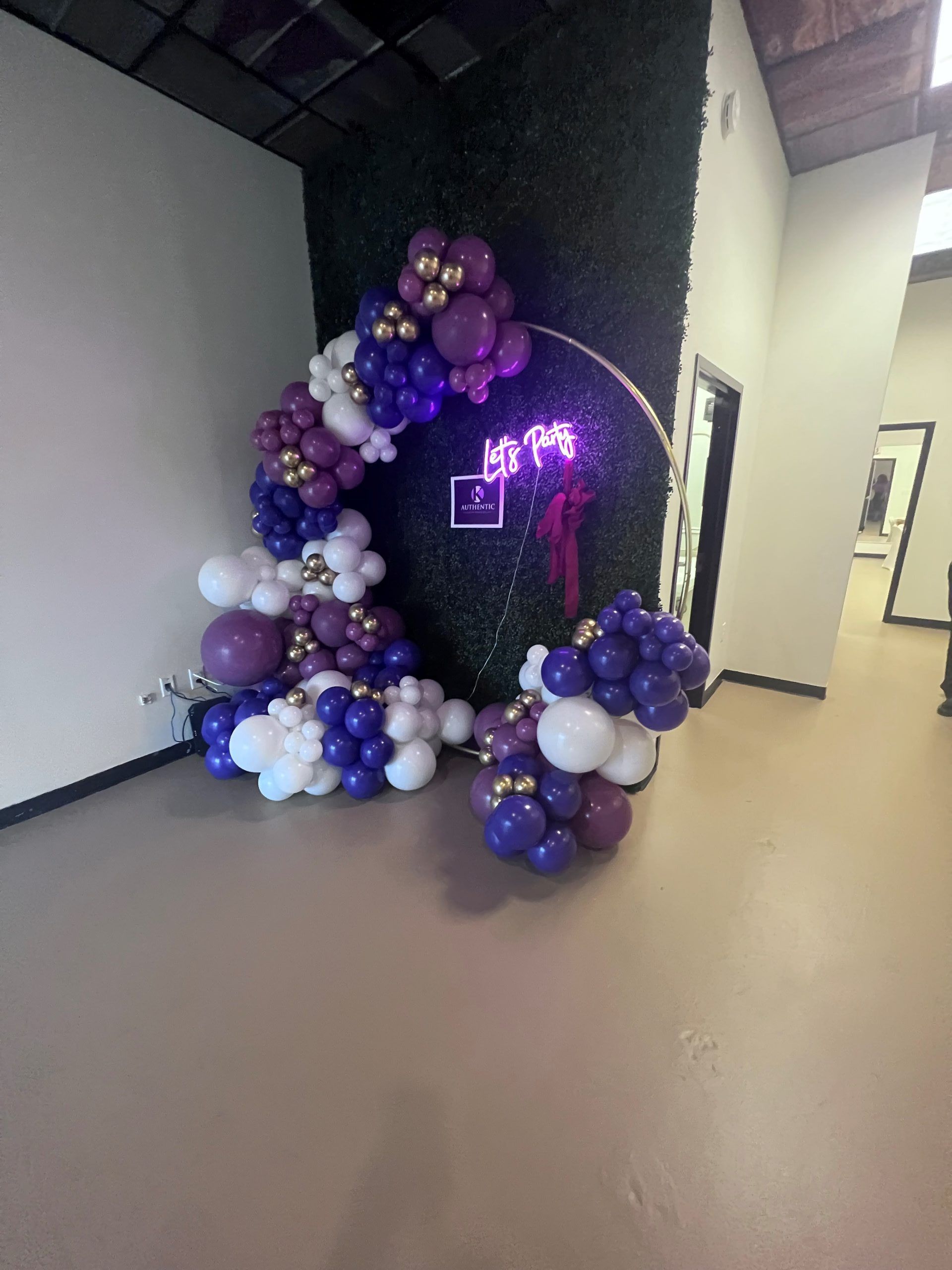 A room filled with balloons and a neon sign.