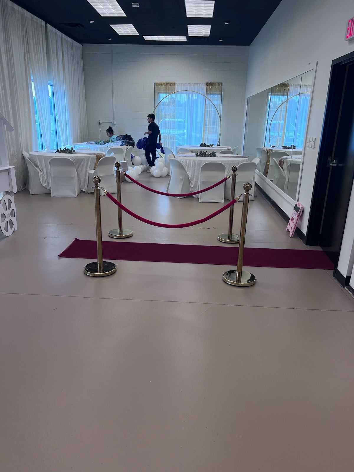 A room with tables and chairs and a red rope barrier.