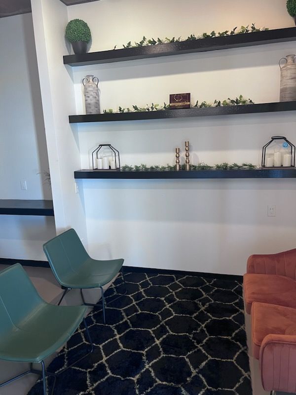 A living room with a couch and chairs and shelves