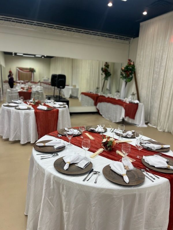 A room with tables and chairs set up for a wedding reception.
