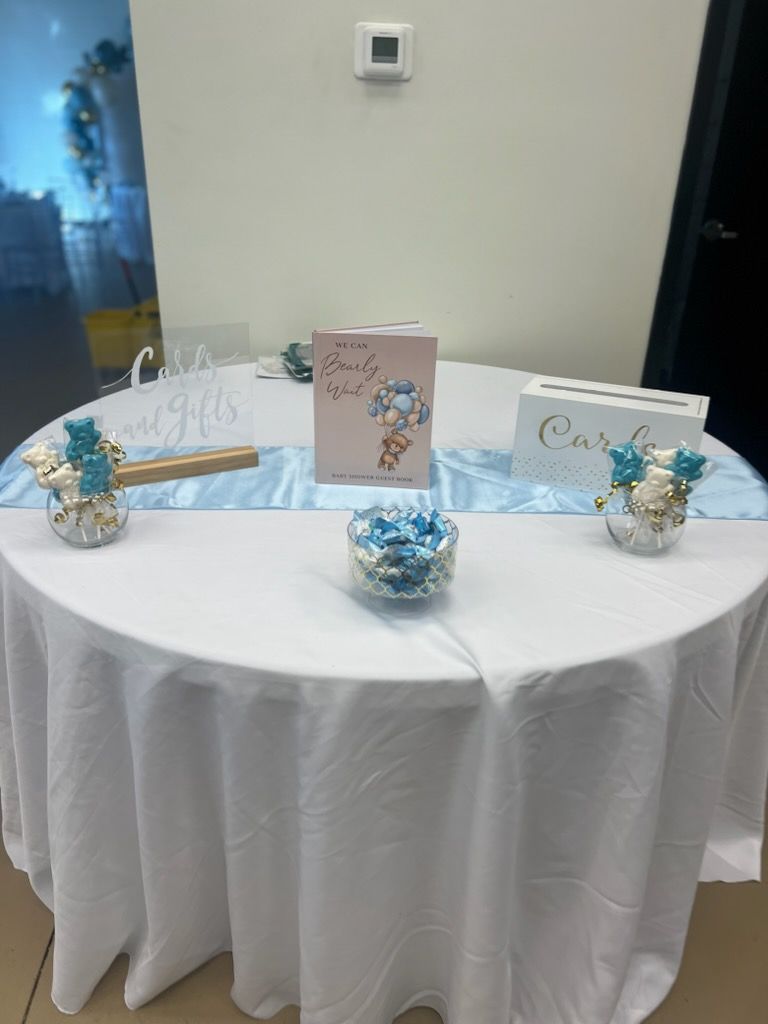 A table with a white table cloth and a card box on it