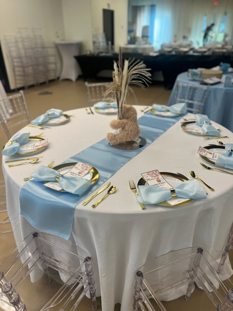 A table set for a baby shower with plates , napkins , and silverware.
