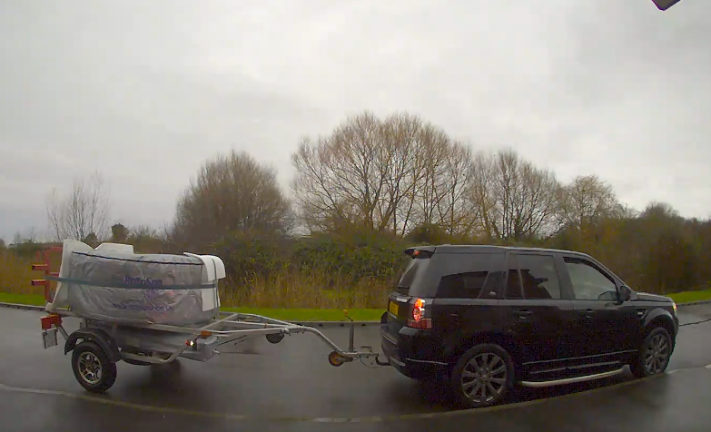 Image of a car pulling a hot tub on a trailer