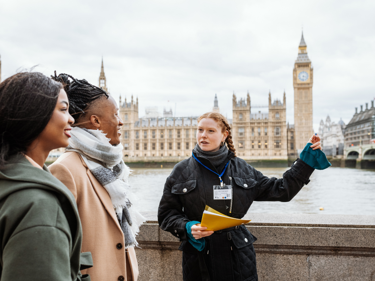 a woman is giving a tour of london to two women 
