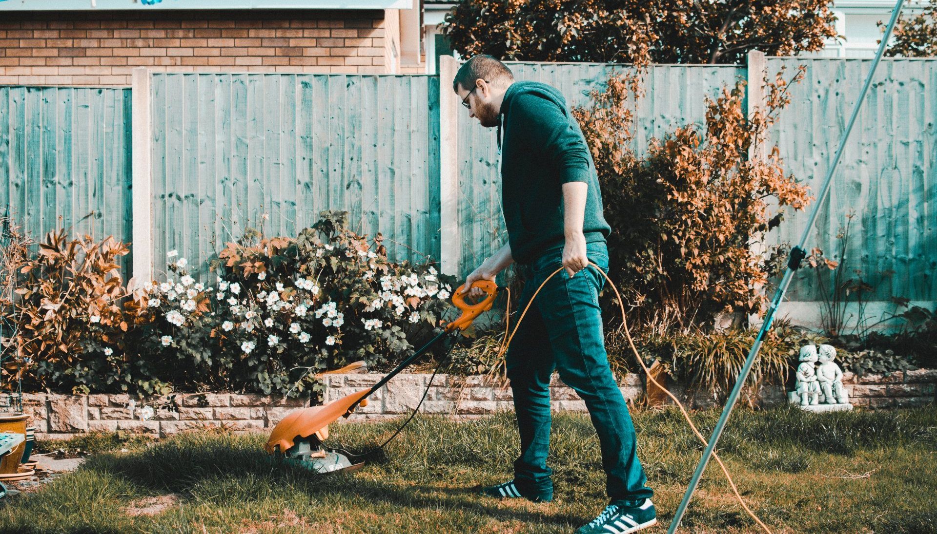 Image of a man trimming the lawn