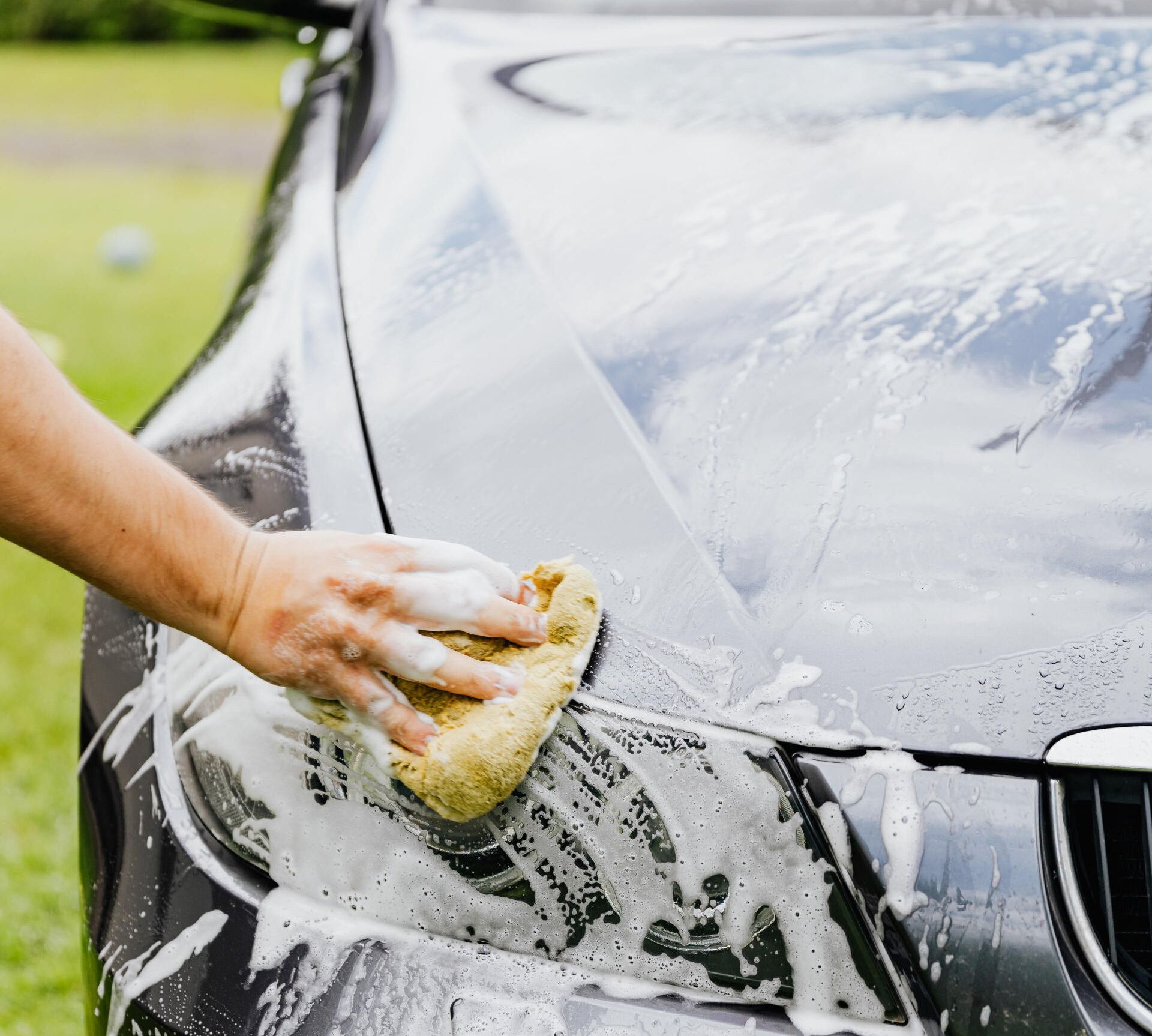a person is washing a car with a sponge .