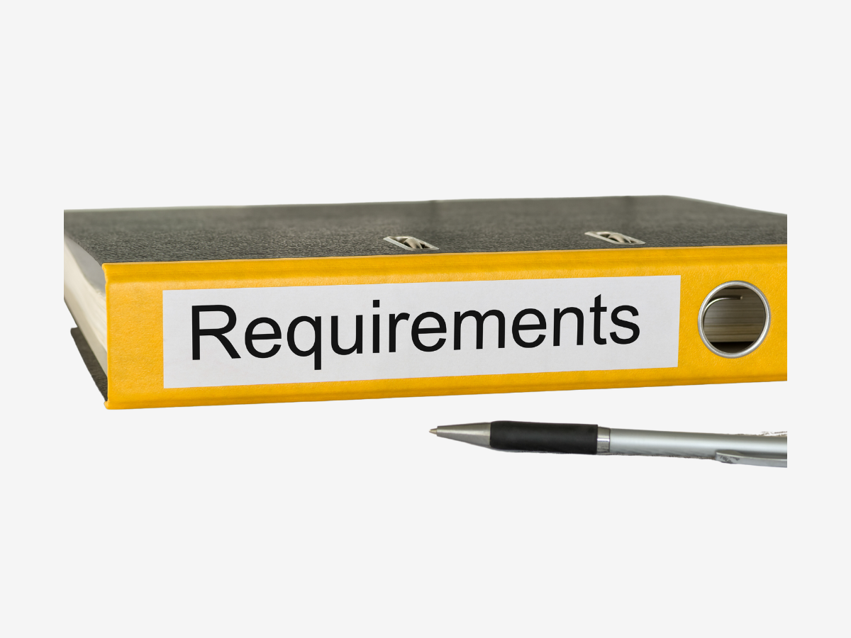 a yellow binder with the word requirements on it next to a pen