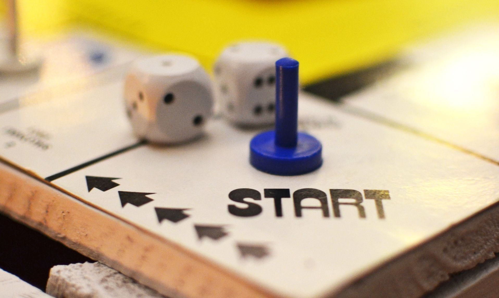 A board game with dice and a blue marker that says start