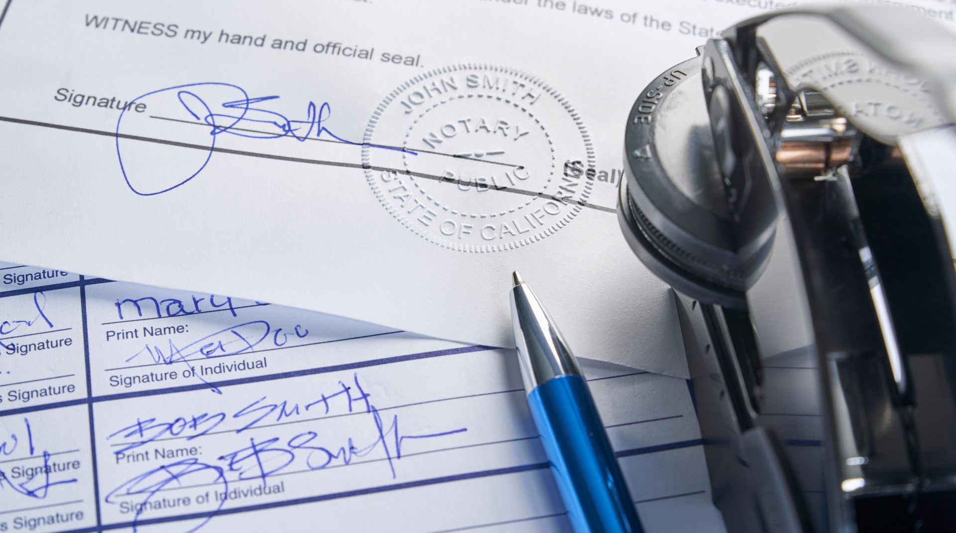Signed legal documents with notary seal, pen, and stapler.