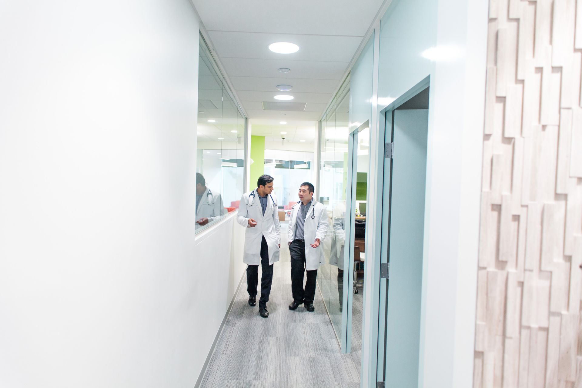 Attune Health providers Dr. Venturupalli and Bryant Uy walking down hallway