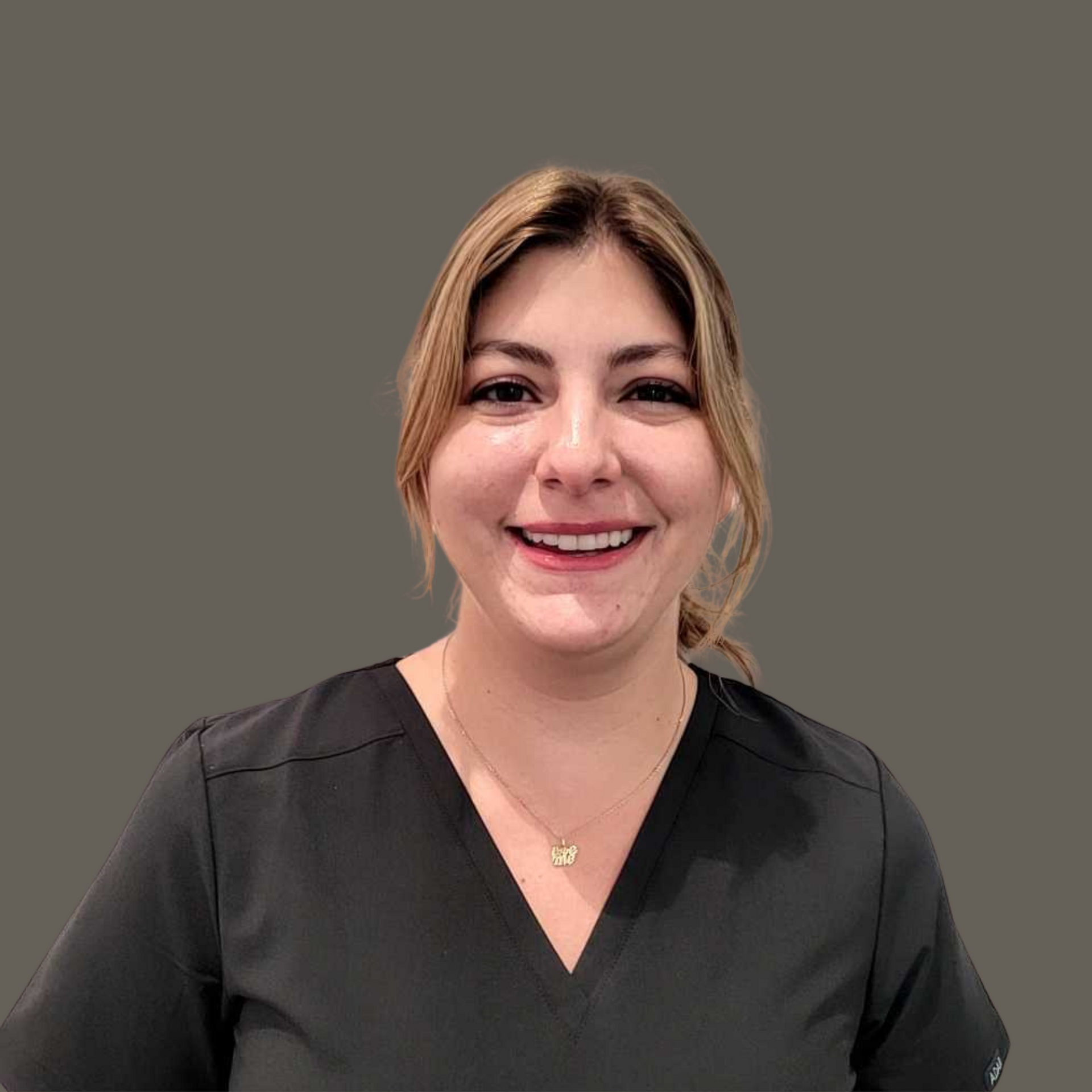 Women standing in front of a solid wall smiling