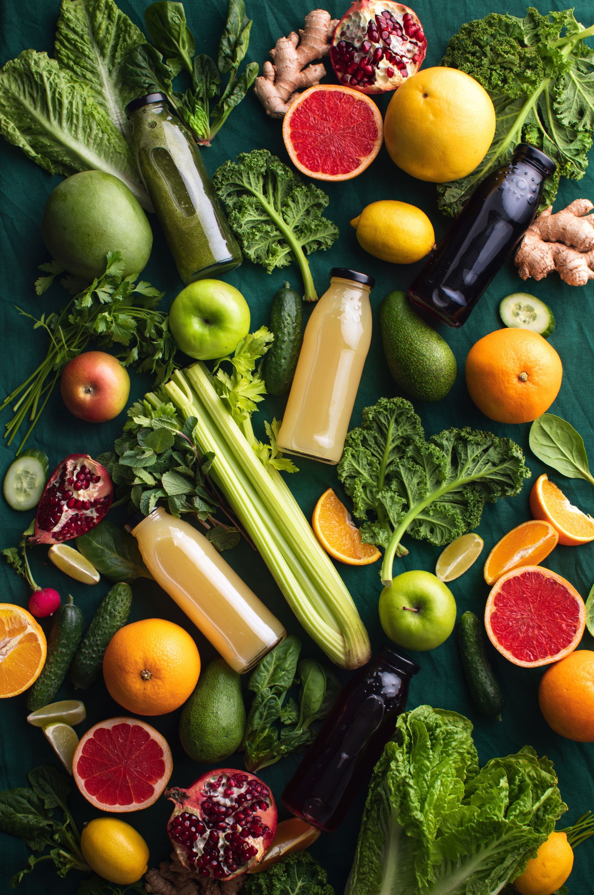 flat lay display of vegetables, fruits and bottles of juice