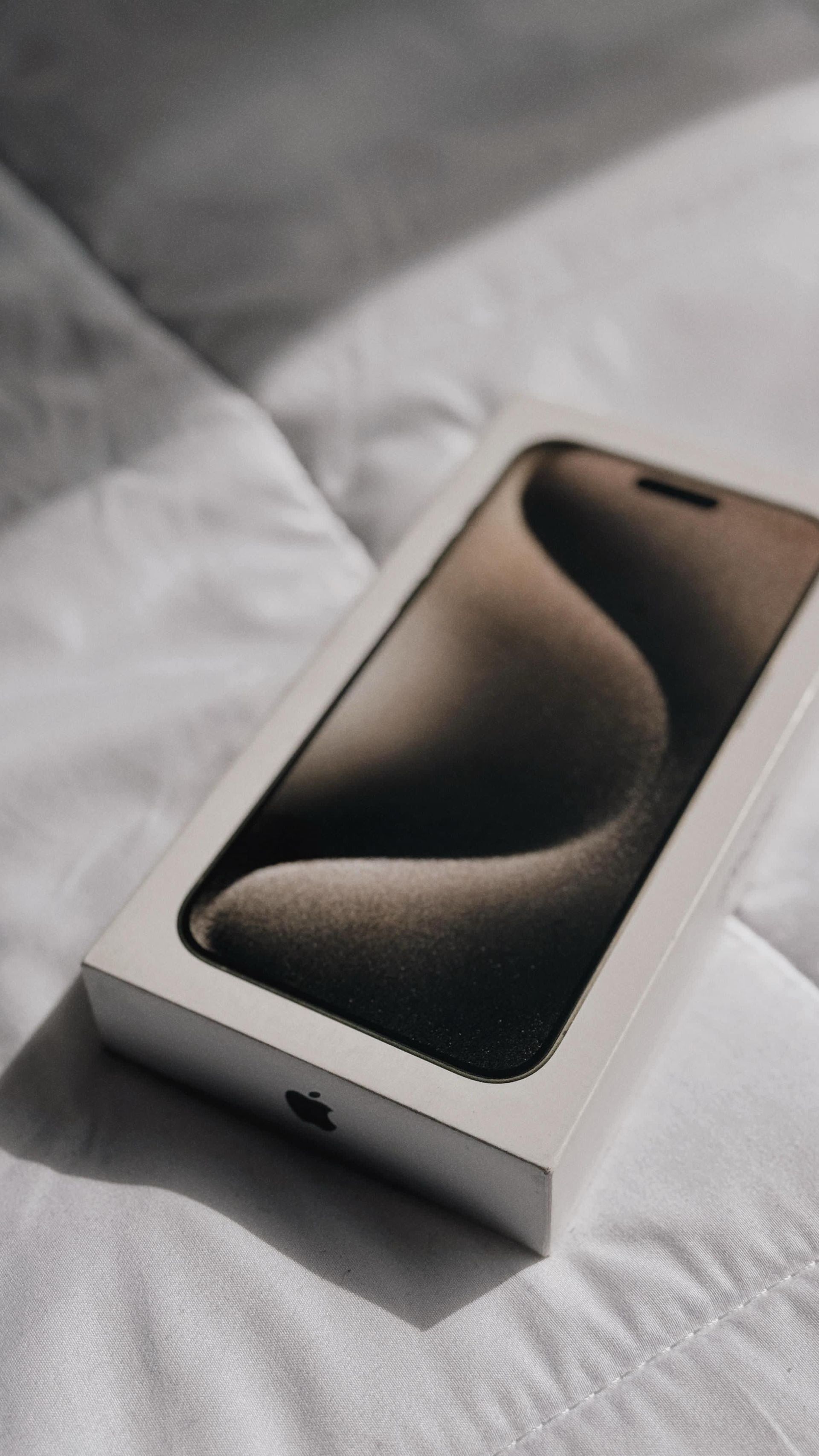 Dos botellas de fragancias Victoria's Secret están sobre una cama.