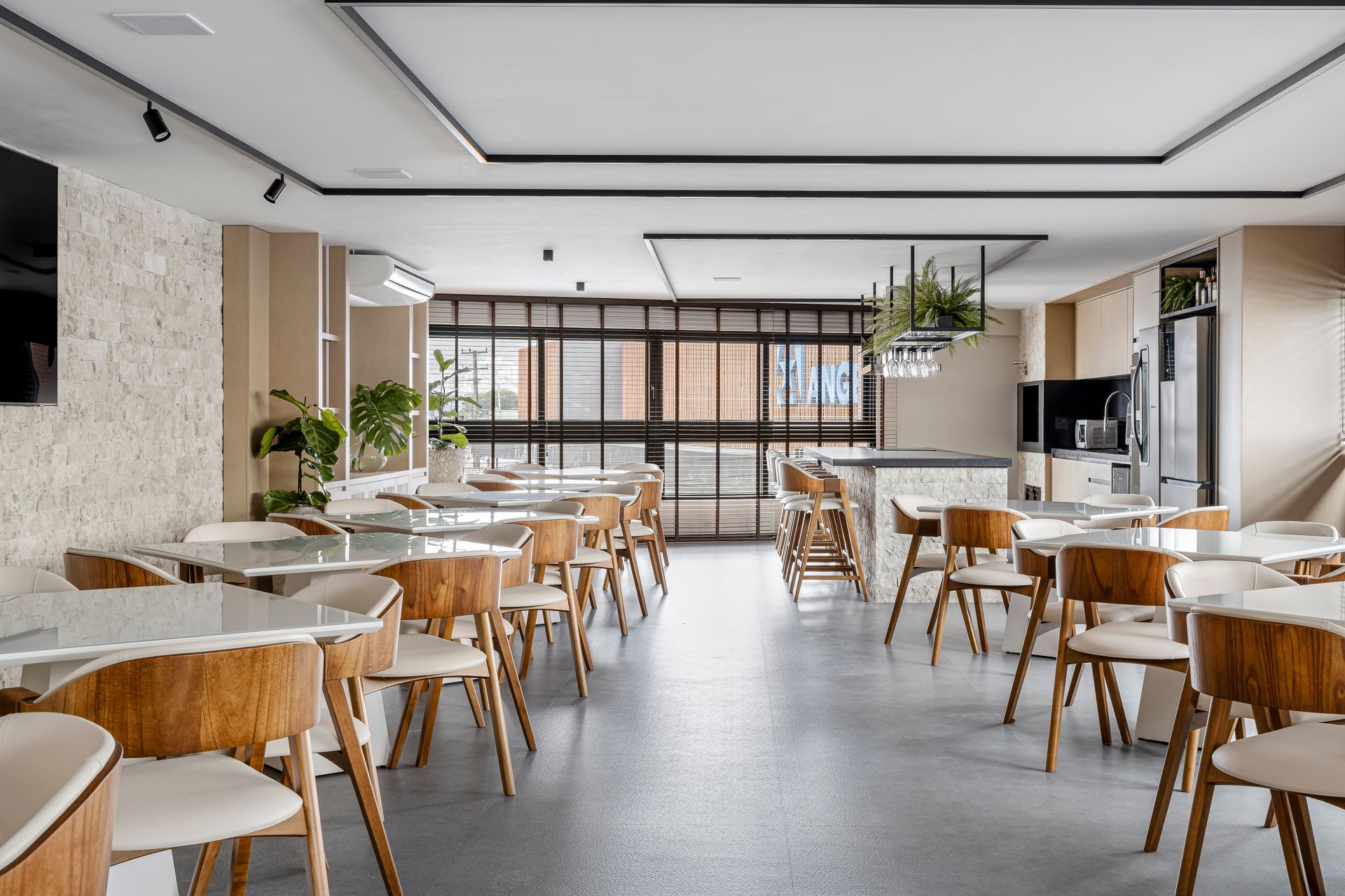 Sala de jantar moderna com cadeiras de madeira, mesas de mármore e plantas.