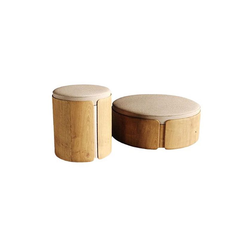 Dois bancos de madeira com tampos almofadados de cor clara. Um é cilíndrico, o outro oval.