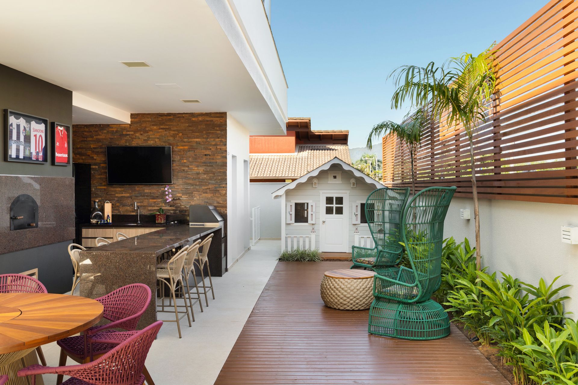 Há uma mesa e cadeiras no quintal de uma casa.