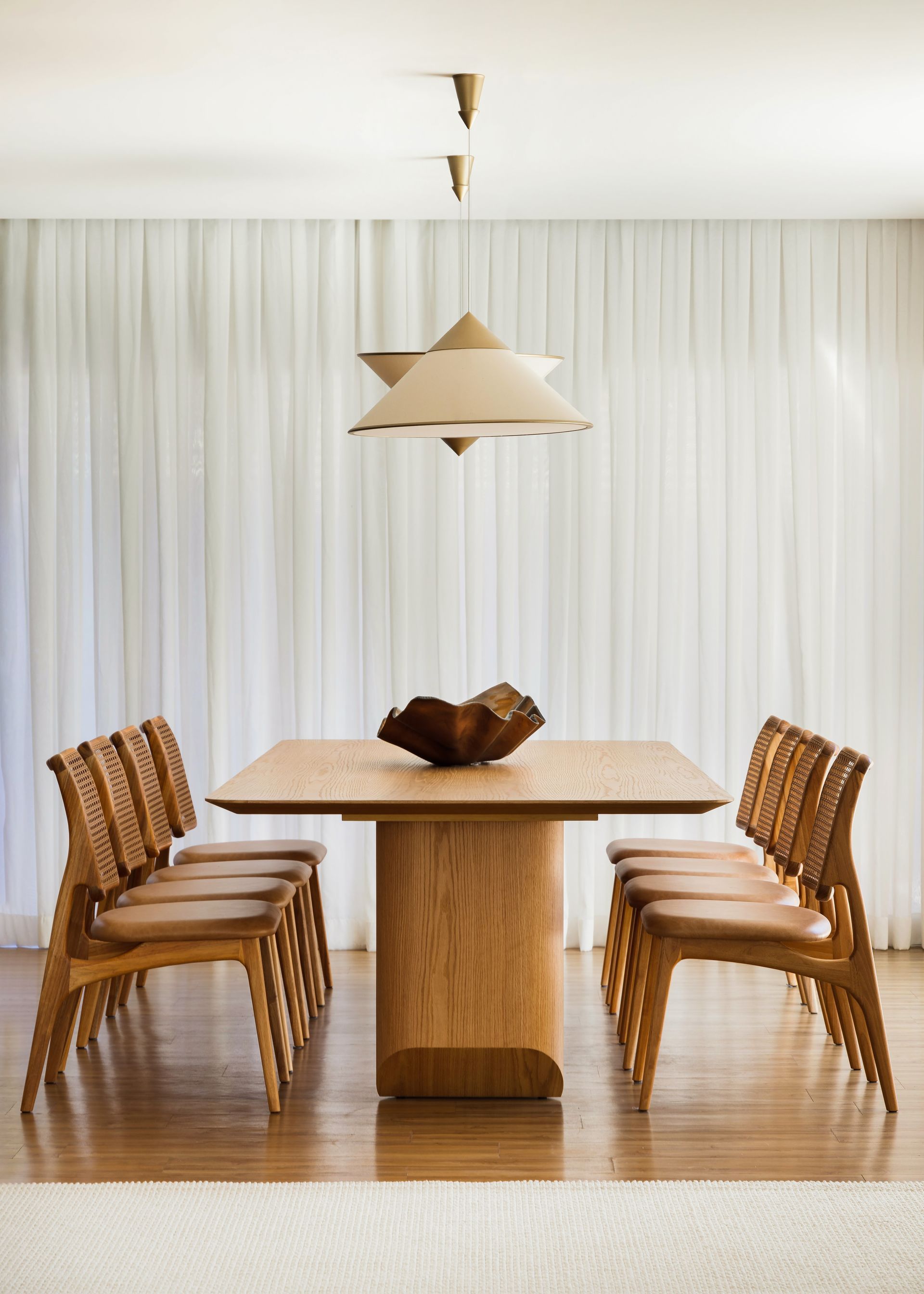 Uma sala de jantar com uma mesa e cadeiras de madeira