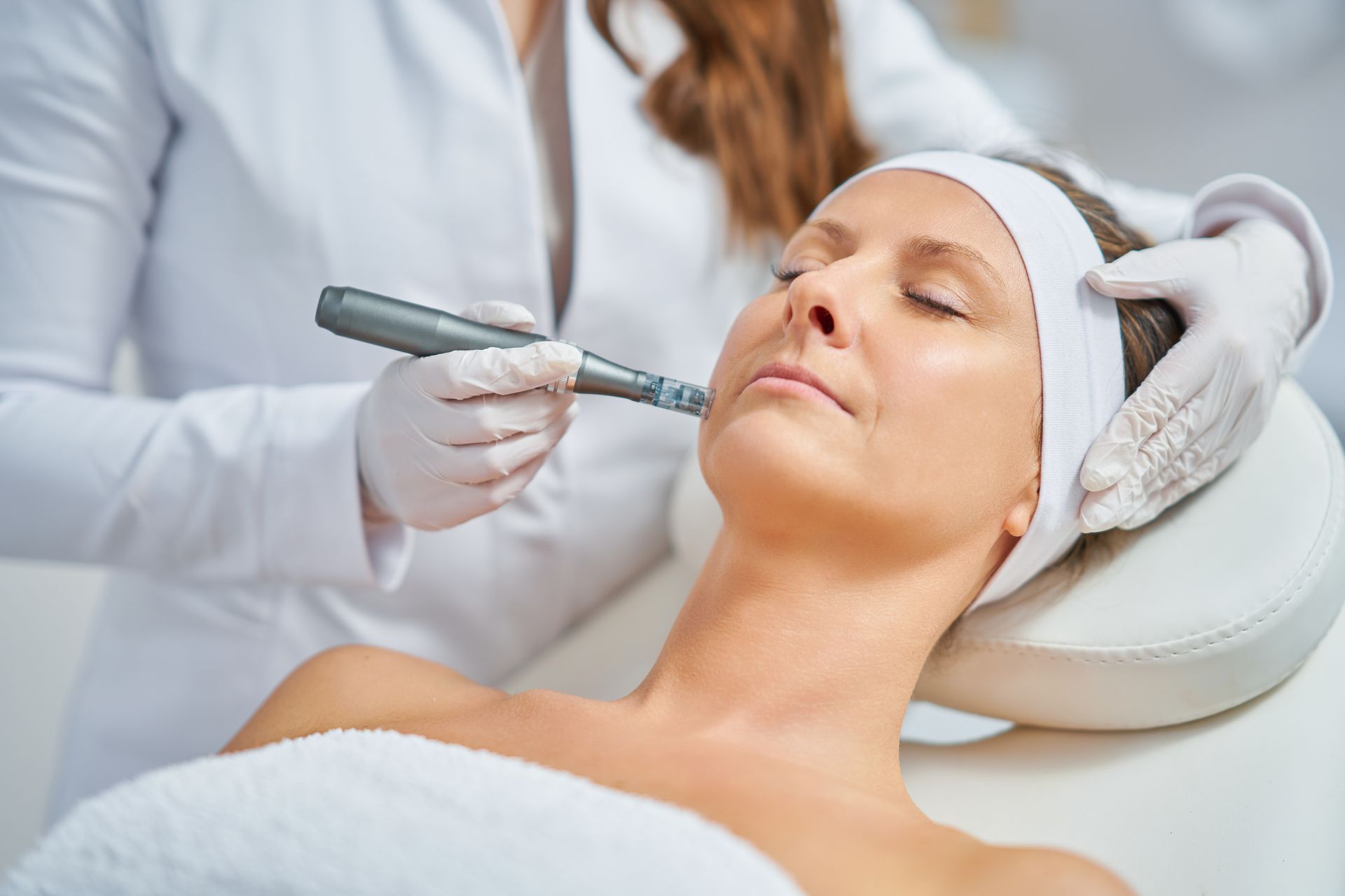 Donna che riceve un trattamento viso con uno strumento sul viso, in un centro benessere.
