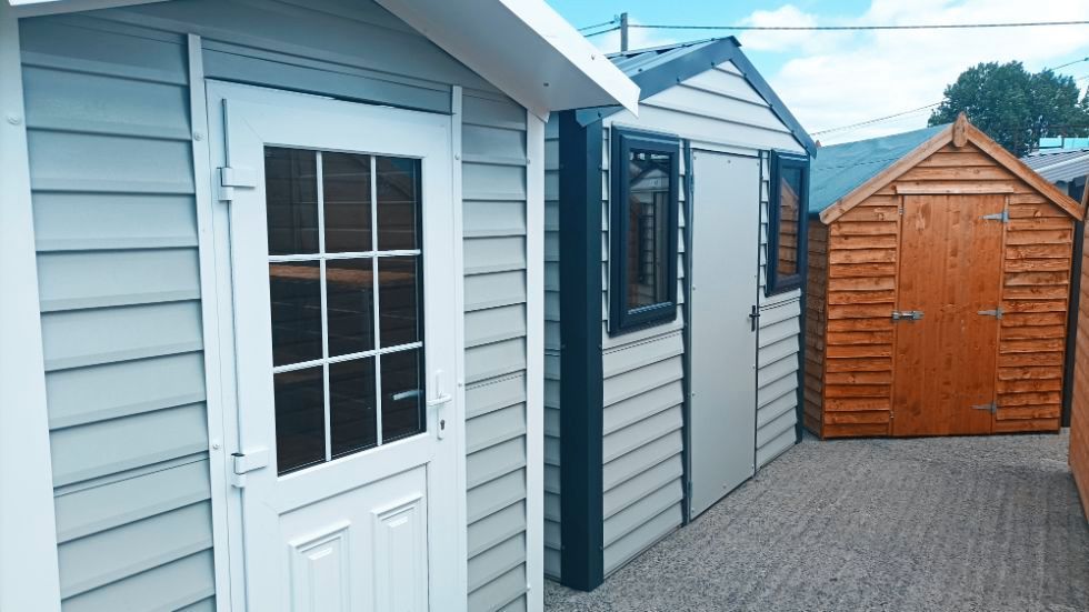 A row of sheds are lined up next to each other in a yard.