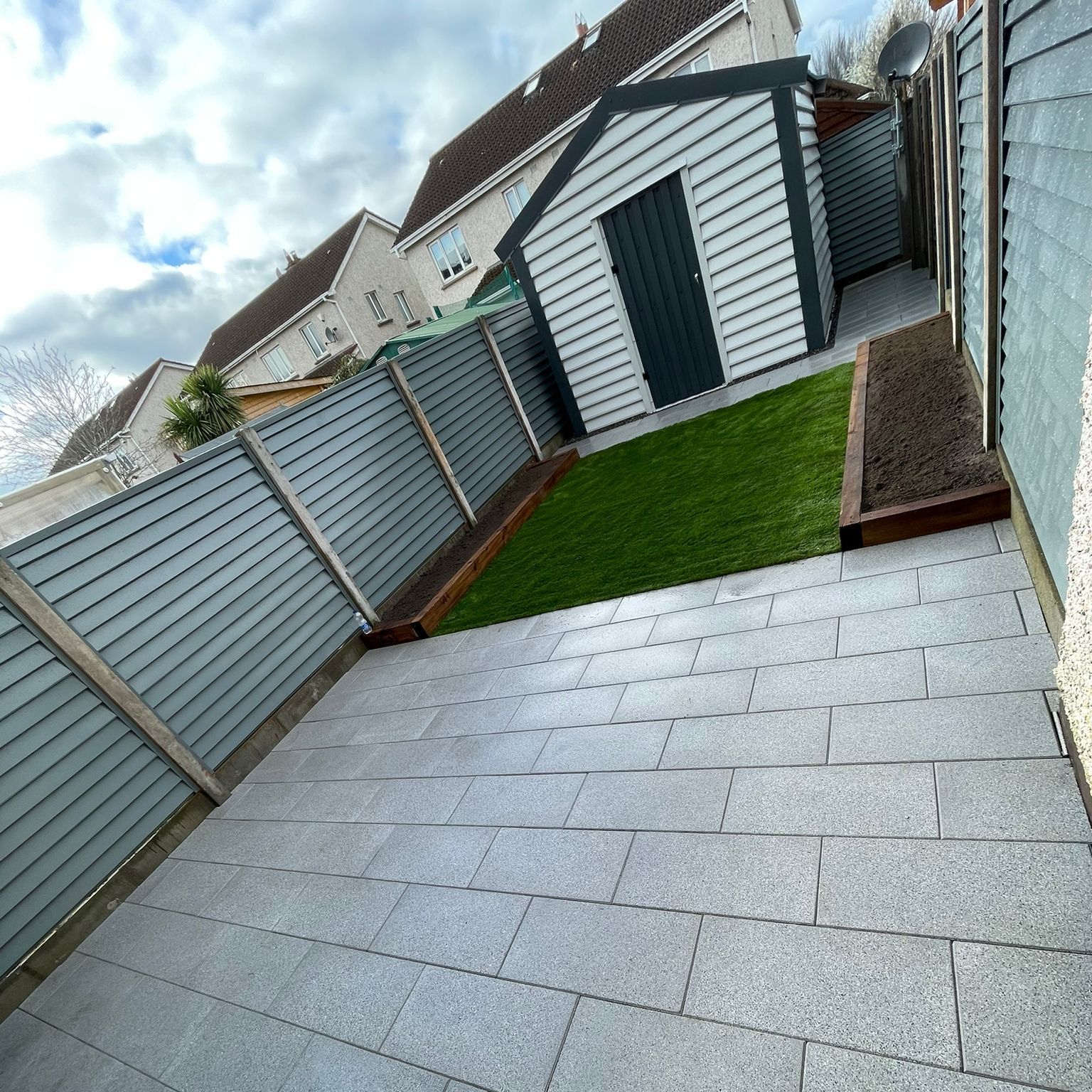 A backyard with a shed and a fence surrounding it