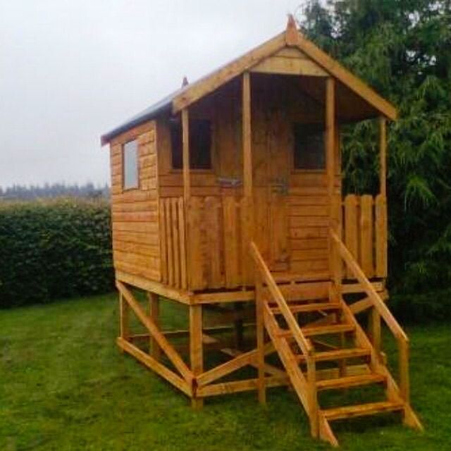 A wooden playhouse with stairs leading up to it