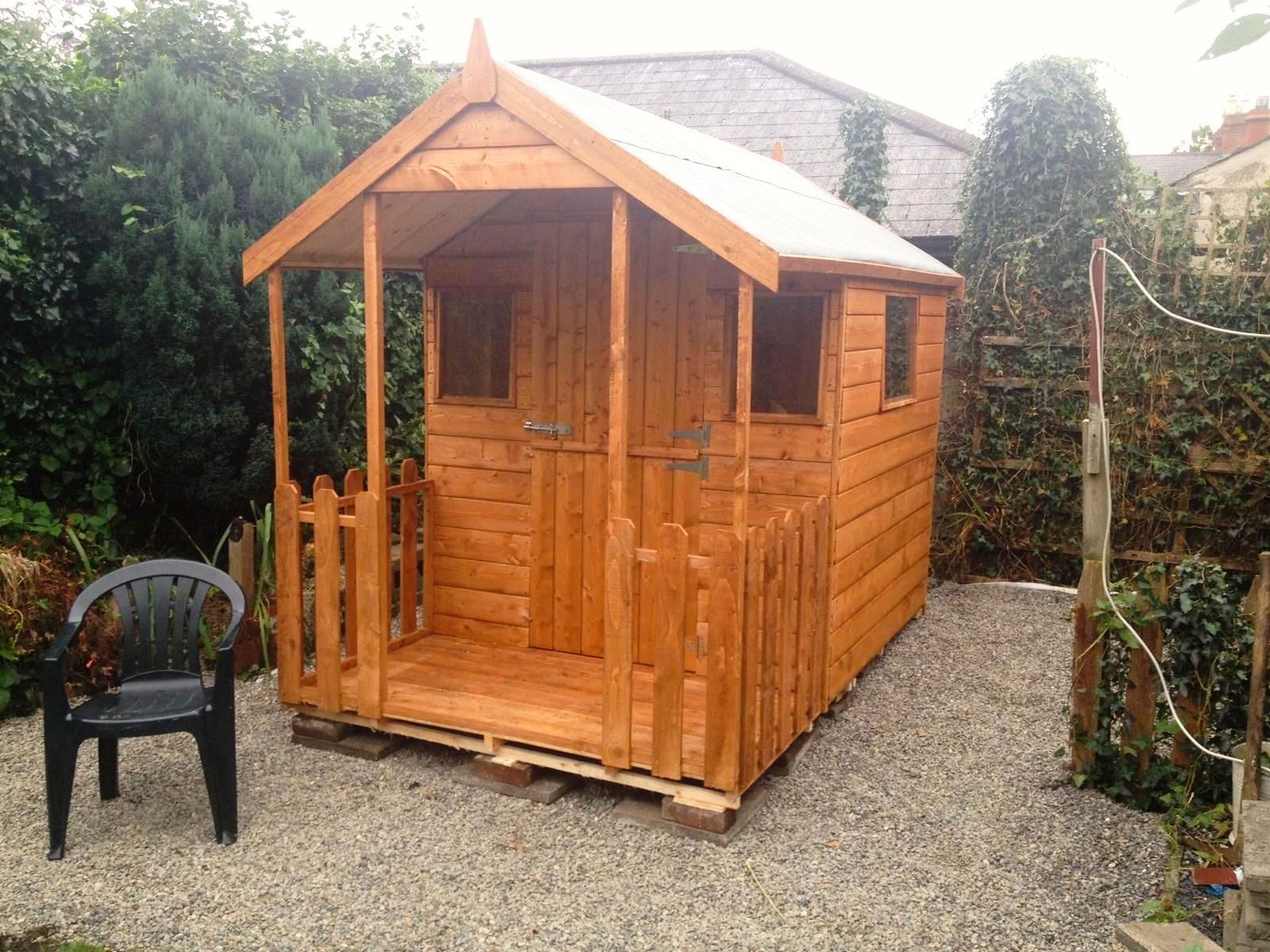 A wooden shed with a black chair in front of it