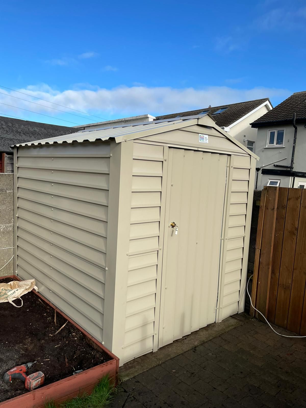 A white shed with a blue sky in the background