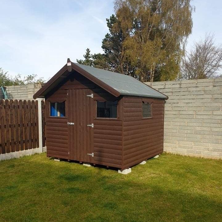 A small wooden shed with a roof and a window
