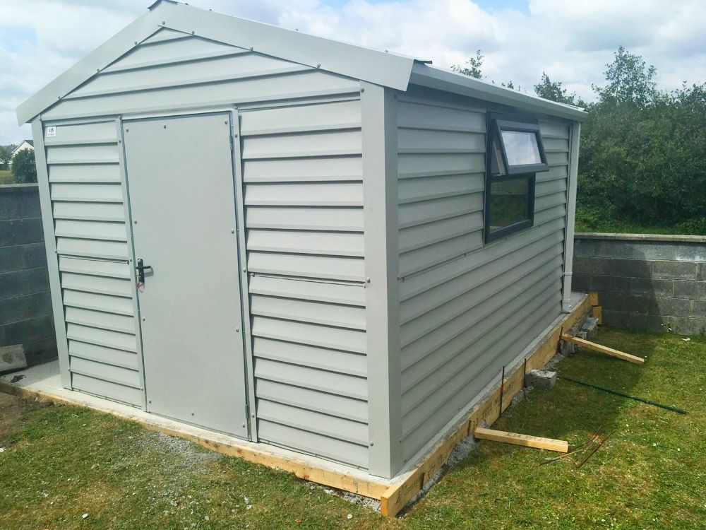 A white shed with a window on the side of it