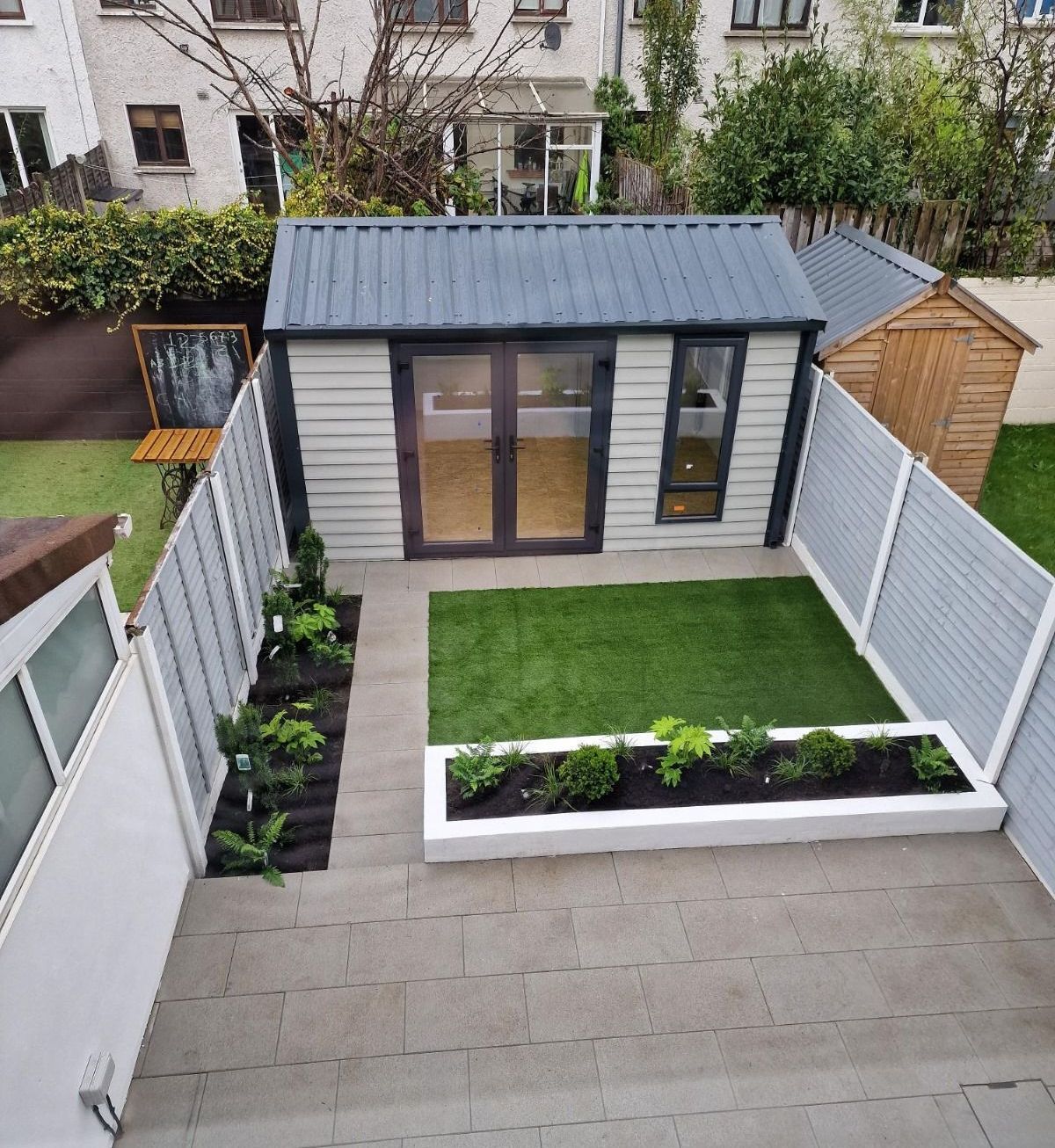 An aerial view of a backyard with a shed and a fence