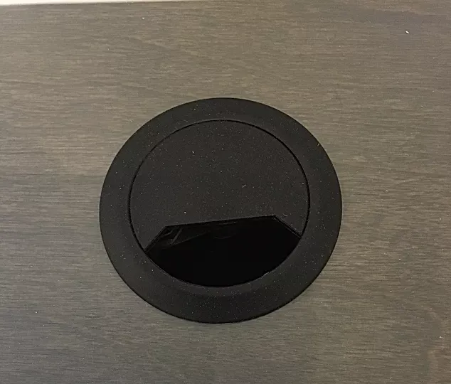A black circle is sitting on top of a wooden surface.