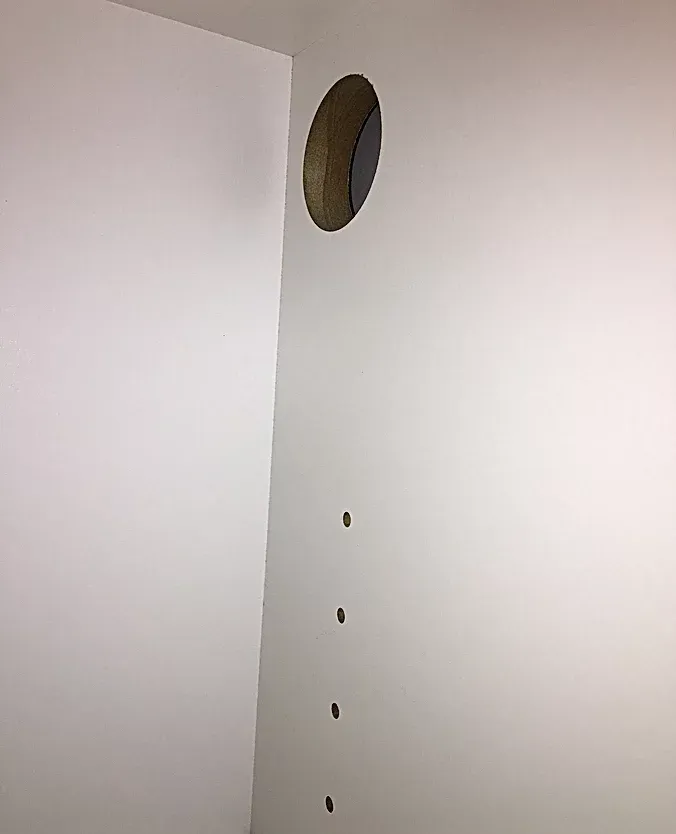 A white wall with a hole in the middle of it