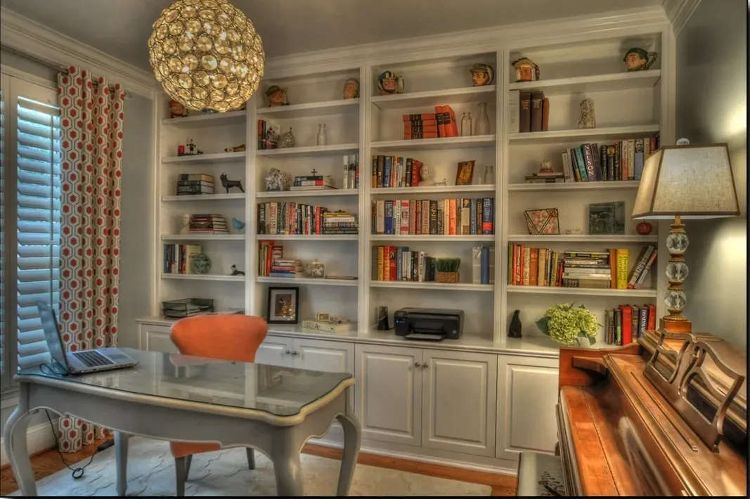 A home office with lots of books on shelves