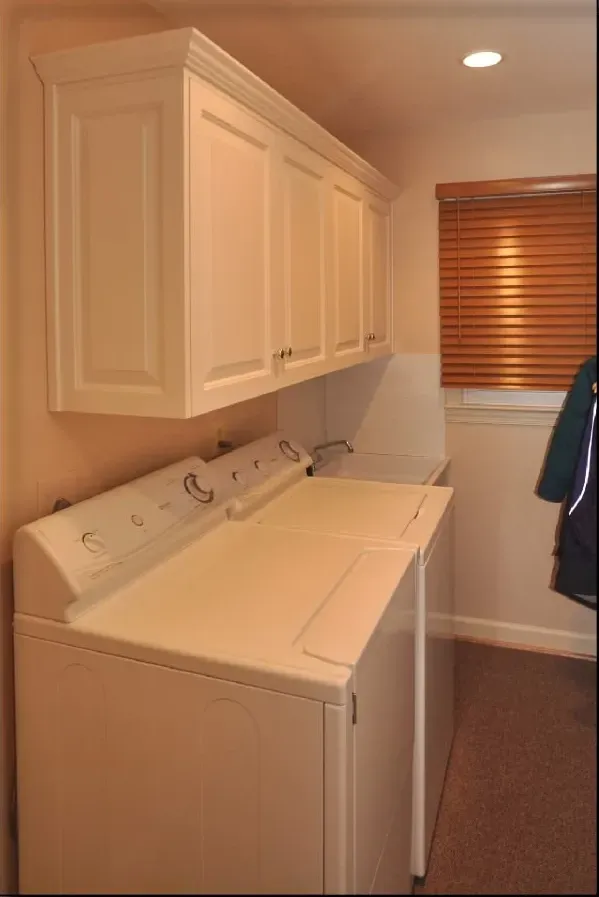 A laundry room with a washer and dryer and cabinets