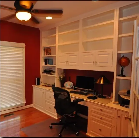 A home office with a desk and chair and a ceiling fan