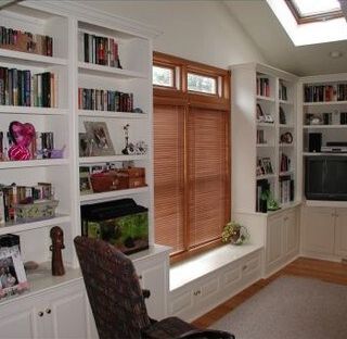 A living room with lots of bookshelves and a fish tank