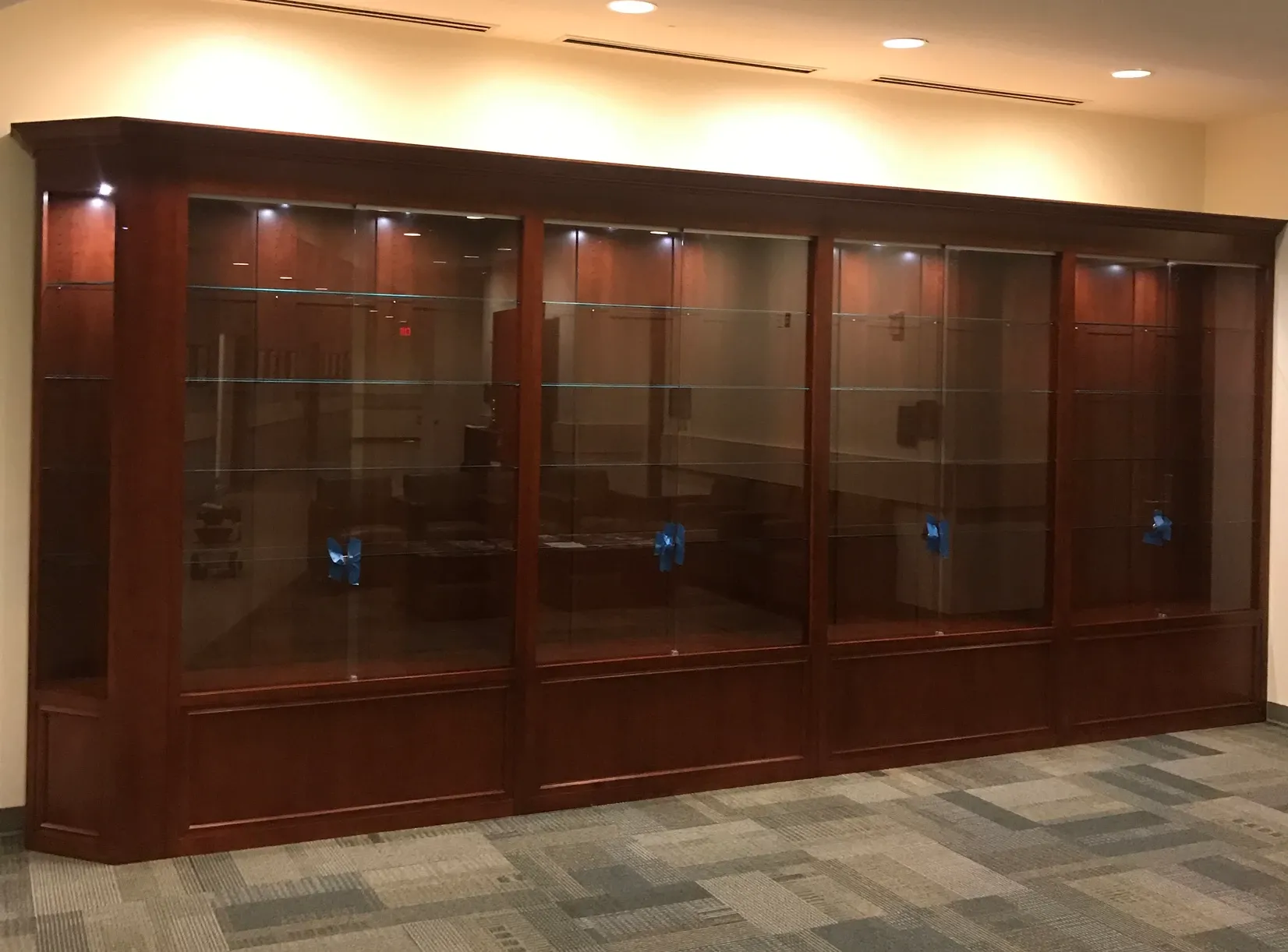 A large wooden cabinet with glass doors and shelves
