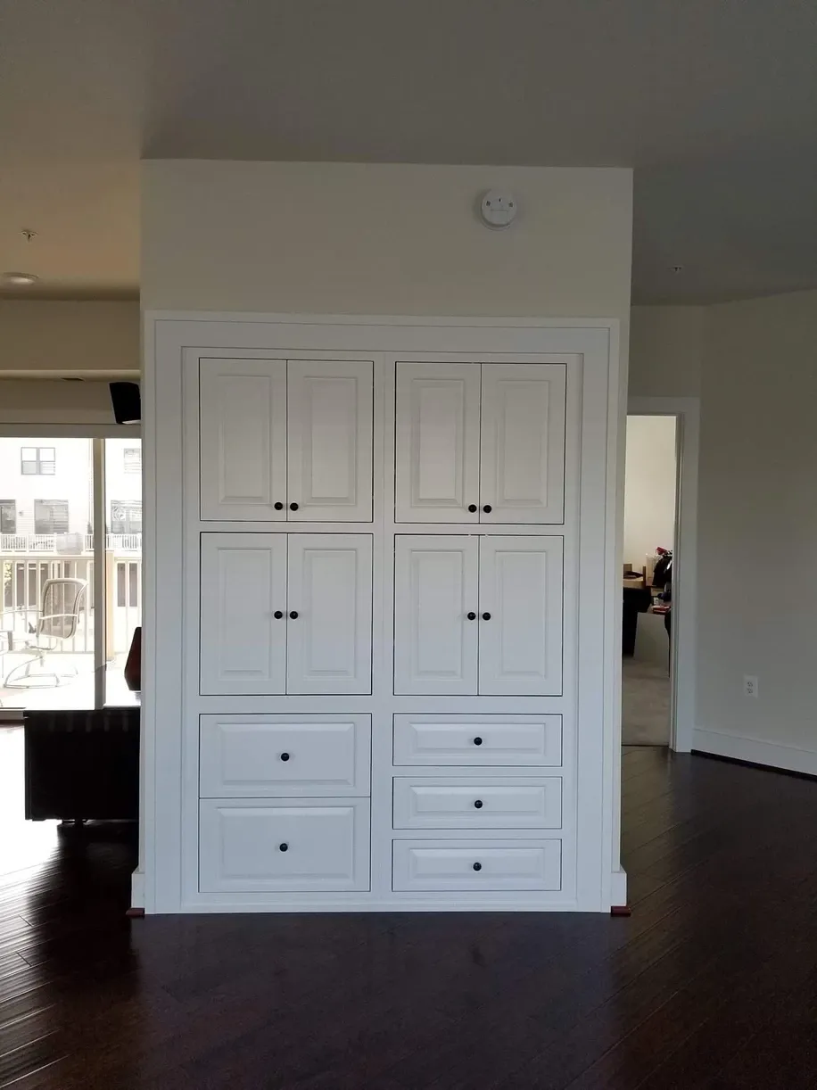 A large white cabinet with drawers in a living room