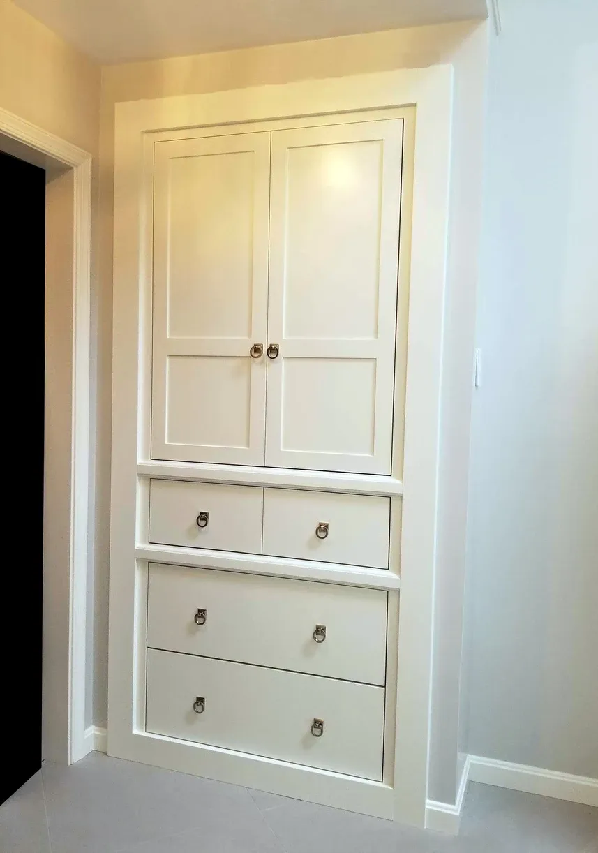 A white cabinet with drawers in a hallway
