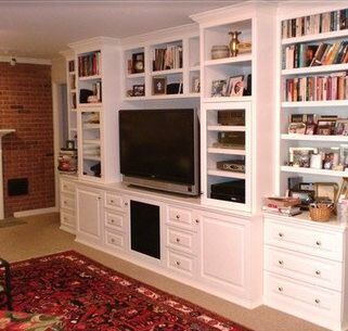 A living room with lots of bookshelves and a flat screen tv