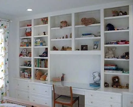 A bedroom with lots of shelves and a desk