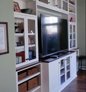 A large flat screen tv is sitting on top of a white entertainment center.