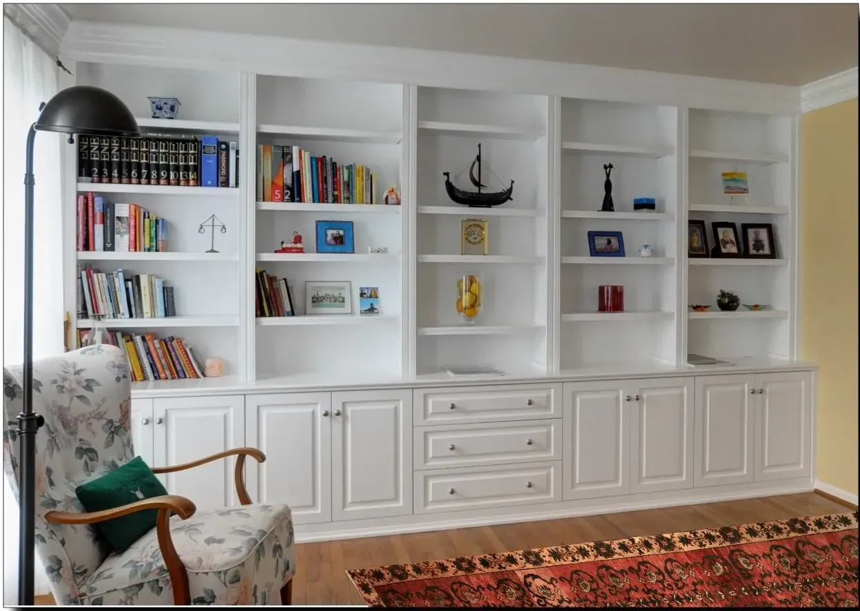 A living room with lots of bookshelves and a chair