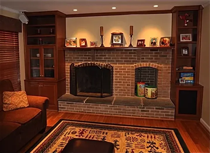 A living room with a brick fireplace and a rug