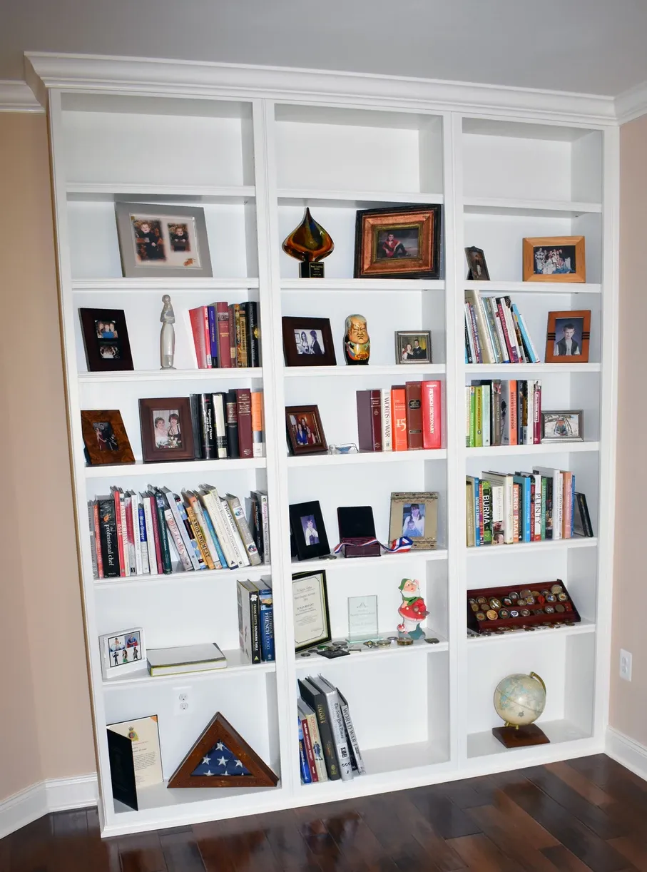 A bookshelf filled with lots of books and pictures