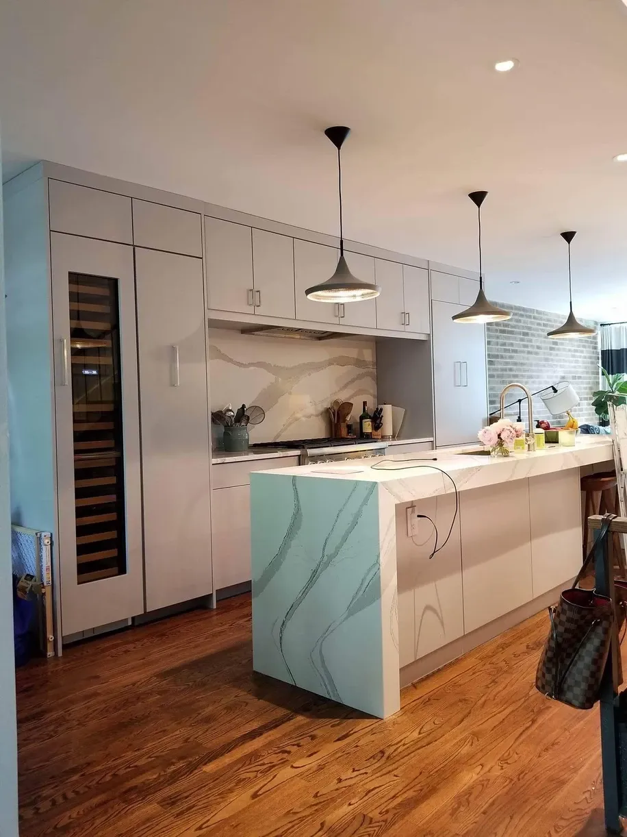 A kitchen with white cabinets and a large island