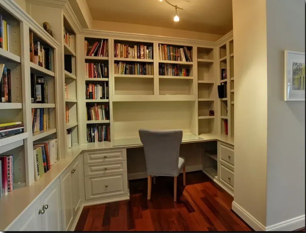 A corner of a room with bookshelves and a desk