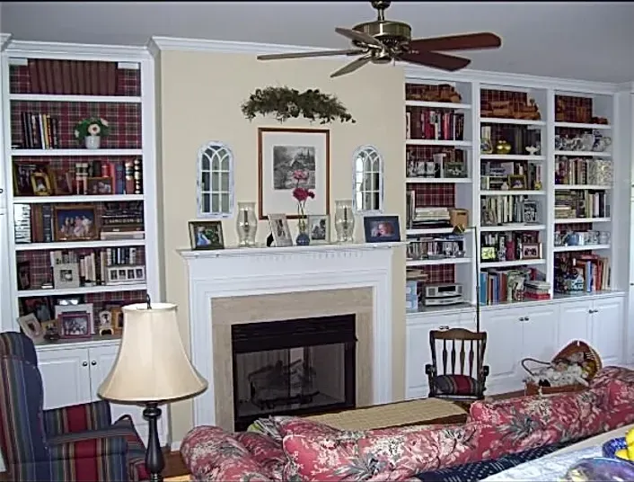 A living room with a fireplace and a ceiling fan