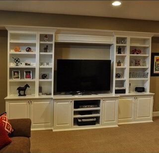 A living room with white cabinets and a flat screen tv